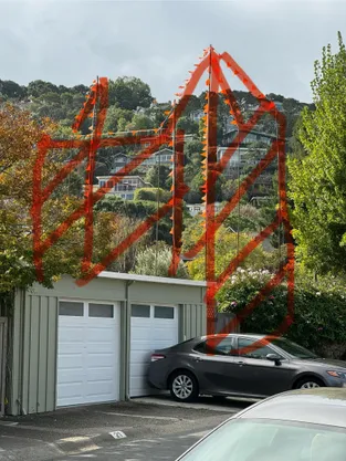 Orange story poles outlining the height of the proposed building next to existing homes on Mallard Road
